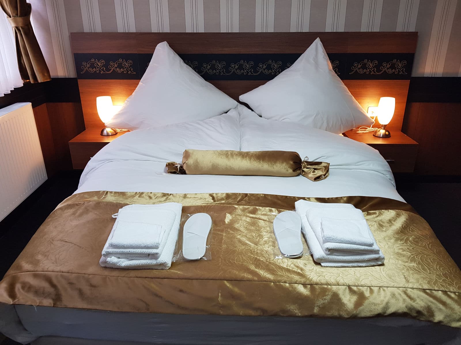 Modernes Hotelzimmer mit Doppelbett und beleuchtetem Kopfteil.