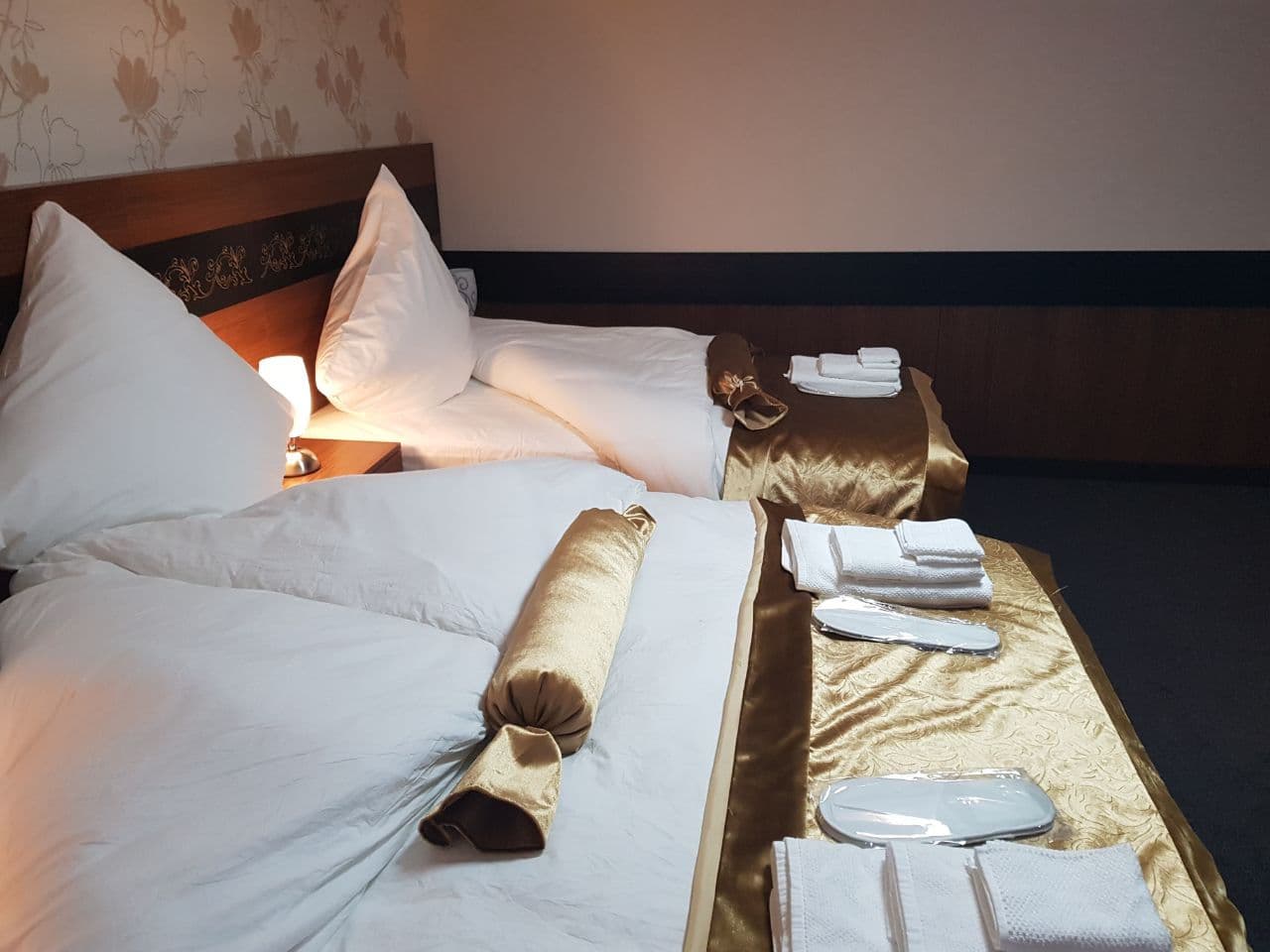 Modern eingerichtetes Doppelzimmer im Hotel Bremer Schlagd mit indirekter Beleuchtung am Kopfende.