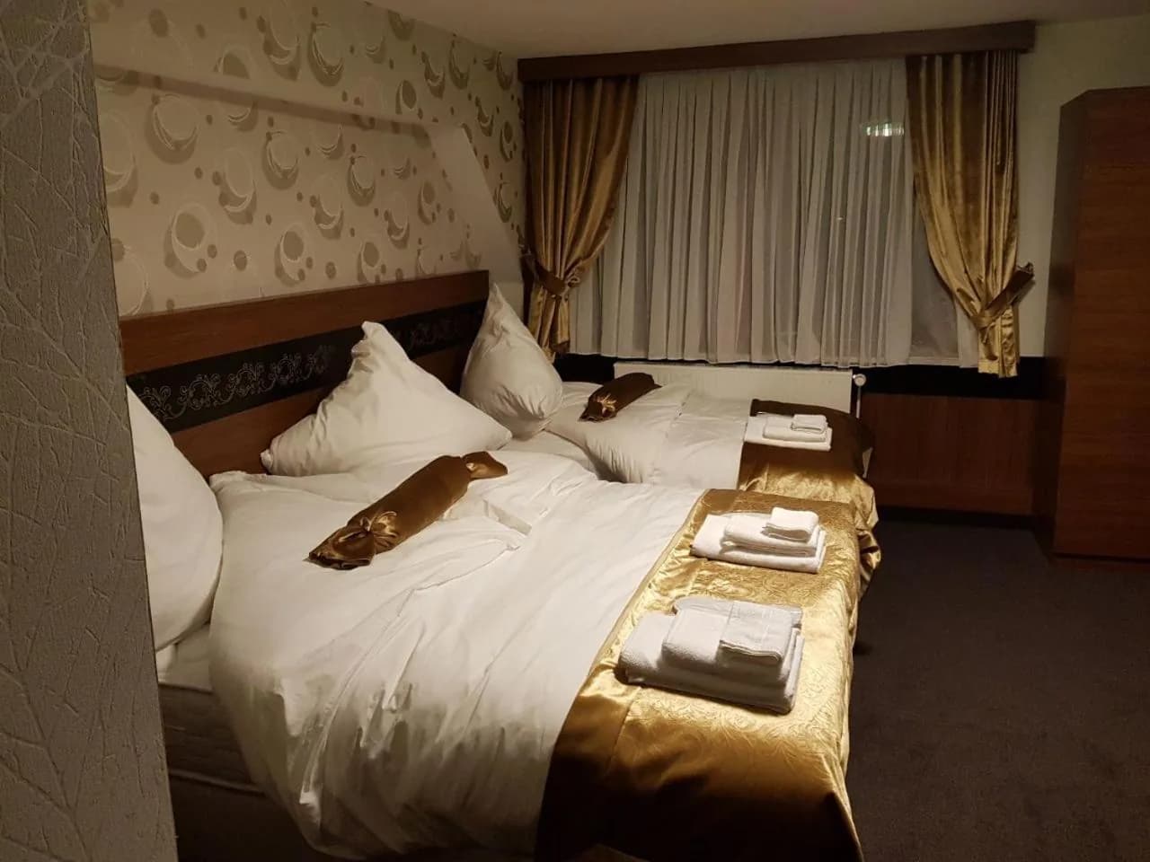 Vierbettzimmer unter der Dachschräge mit Betten und Kleiderschrank