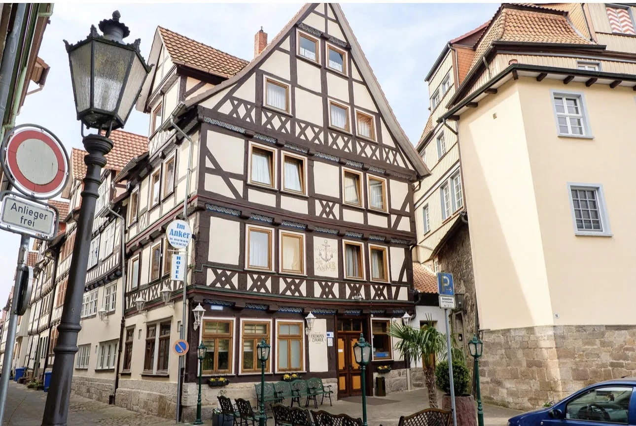 Fachwerk-Fassade des Hotel Bremer Schlagd mit Eingang, Straßenlaterne und Terrassenstühlen in der Altstadt von Hann. Münden