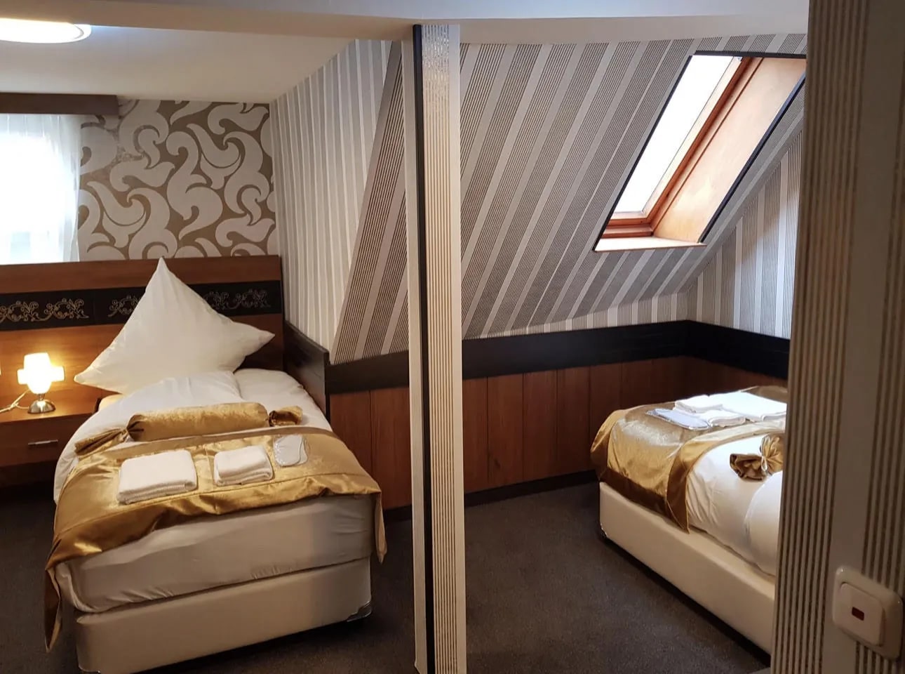 Zweibettzimmer unterm Dach mit Dachschräge, Dachfenster und zwei Einzelbetten