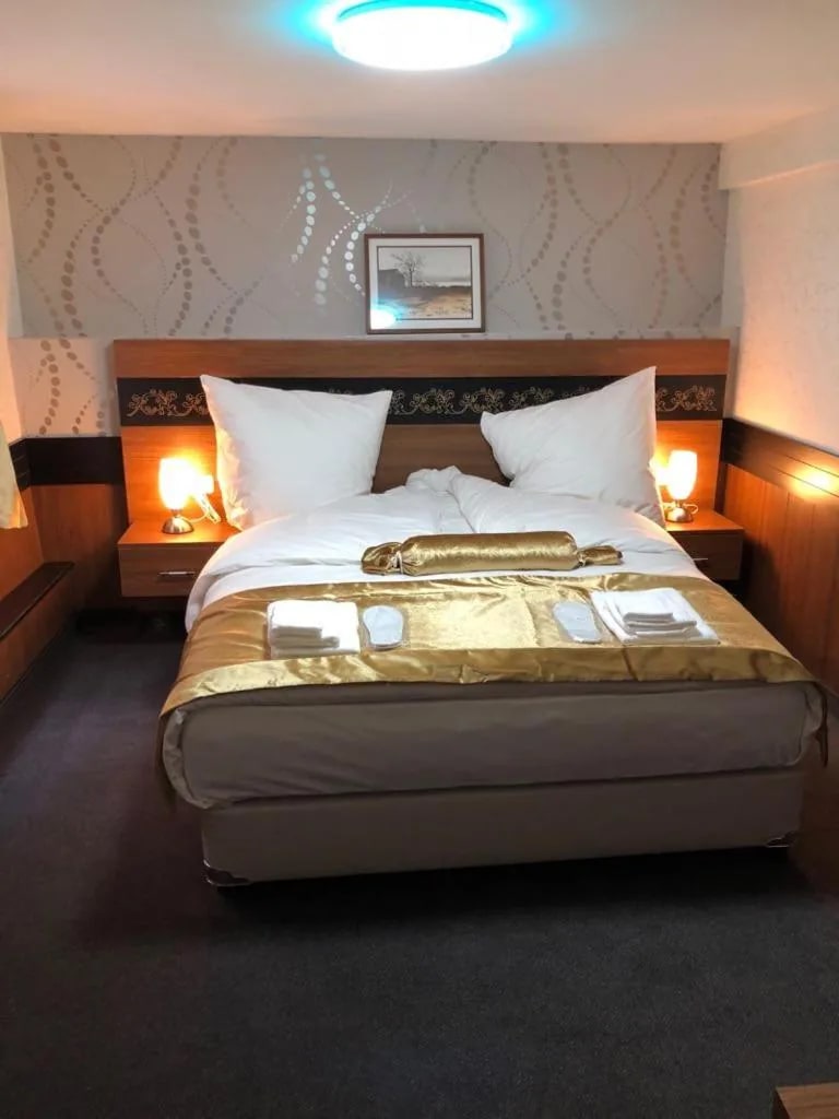 Doppelzimmer mit Wandbild, Deckenleuchte und Doppelbett