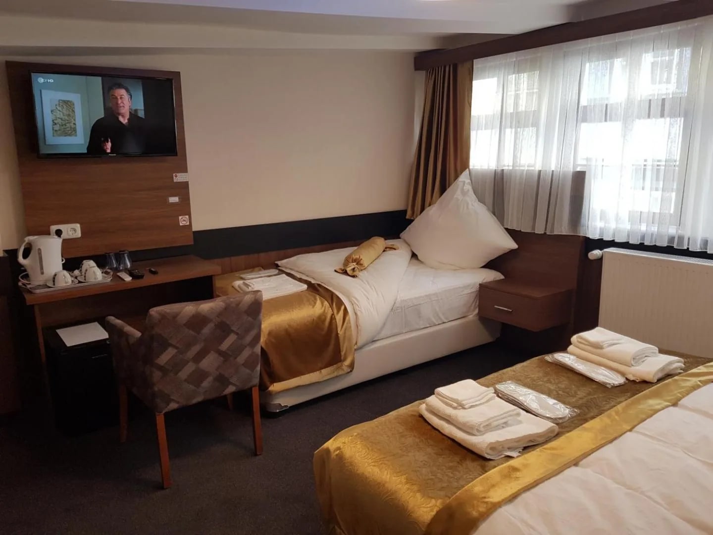 Einzelbett im Dreibettzimmer mit Flat-TV und Schreibtisch