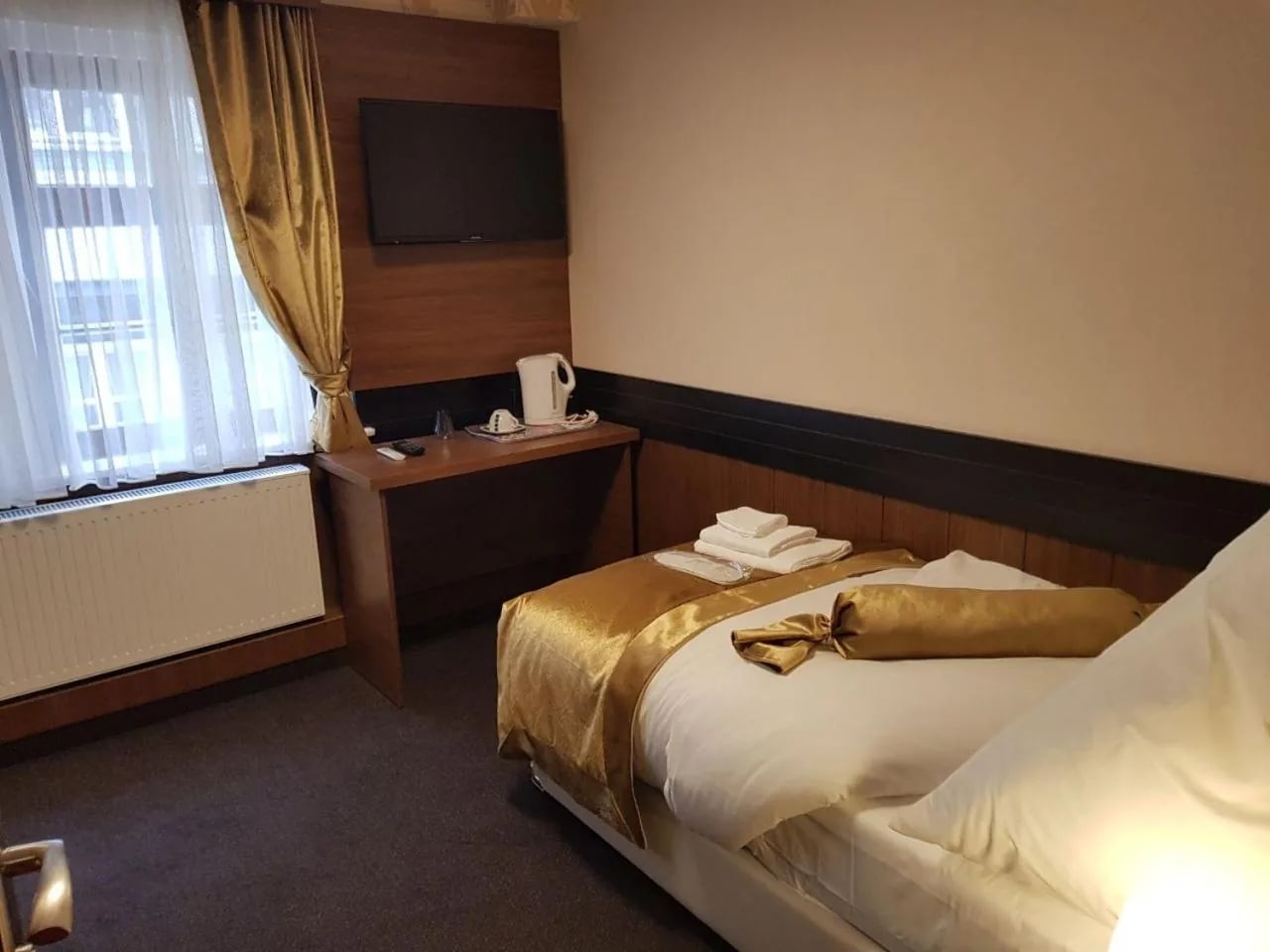 Einzelzimmer im Überblick mit Schreibtisch, Flat-TV und Fenster