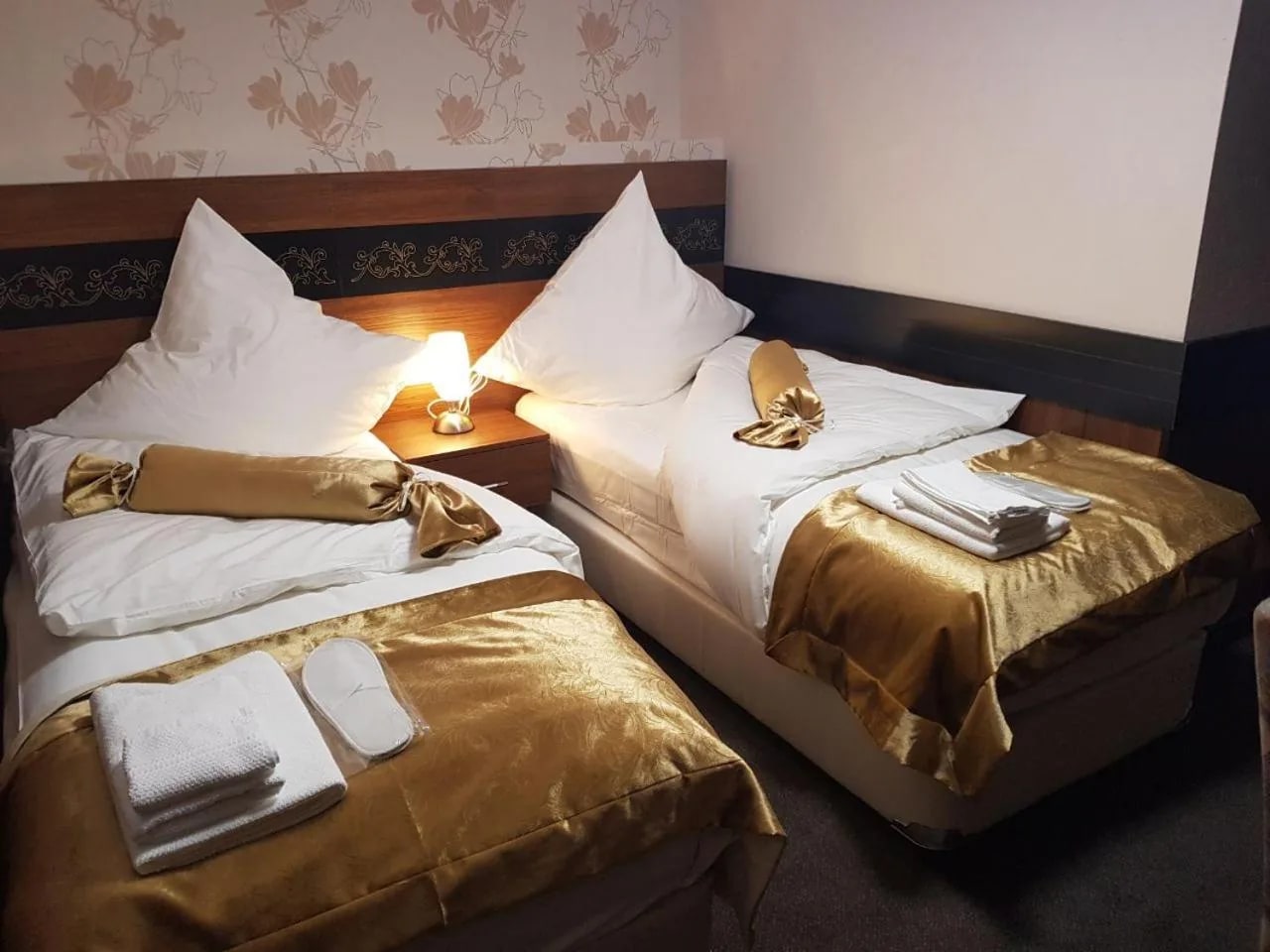 Zwei Betten im Familienzimmer mit goldenen Tagesdecken