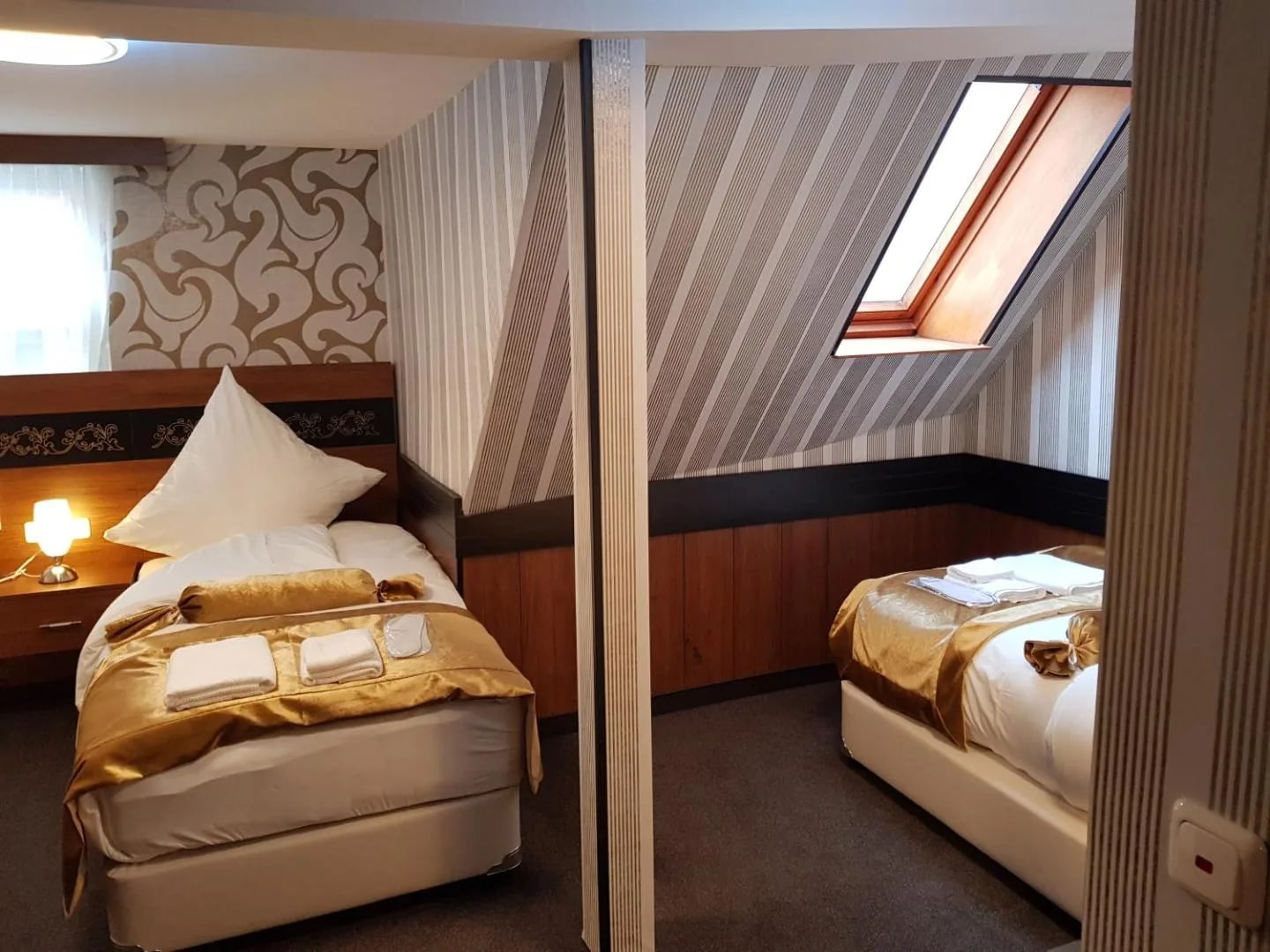 Zweibettzimmer mit Dachschräge und Raumteiler zwischen den Betten